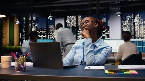 Black manager thinking about new ideas while reviewing notes on laptop Stock Photos