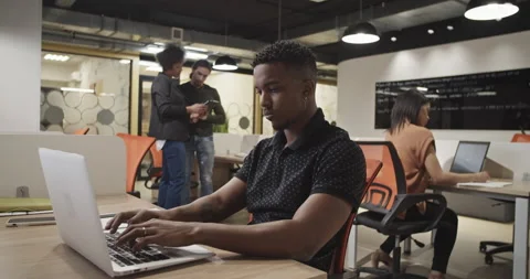 Black manager using laptop near coworkers Stock Footage 195221232