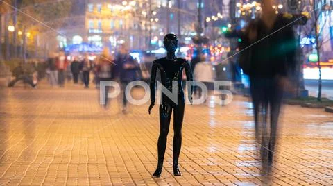 The black mannequin standing on the crowd street. evening time Stock Photos
