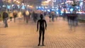 The black mannequin standing in an evening street with a people stream 4k or 4k+ Resolution