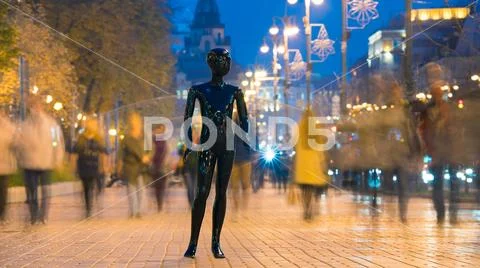 The black mannequin standing on the evening street with people Stock Photos