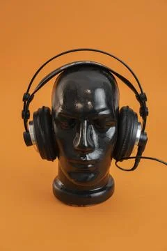 Black mannequin`s head wearing set of headphones Stock Photos