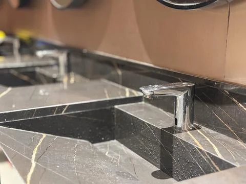 Black Marble Bathroom Sink with Automatic Sensor Faucet in Upscale Interior Stock Photos