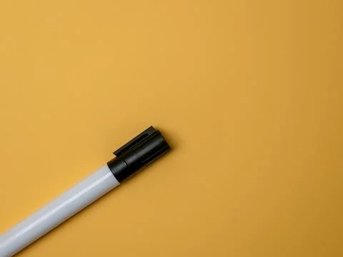 Black marker pen on a solid yellow background with copy space Stock Photos