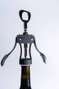 Black matte corkscrew opening wine bottle Stock Photos