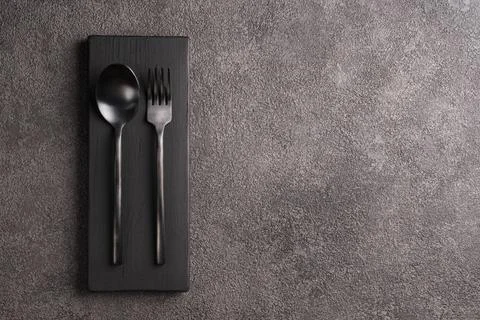 Black matte spoon and fork. Minimalistic set, copyspace for a restaurant or cafe Foto stock