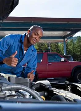 Black mechanic working on car engine Foto stock