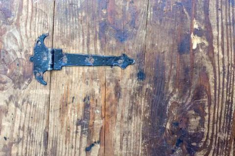 Black, medieval-style iron loop with nails on background of old, stained, cra Stock Photos
