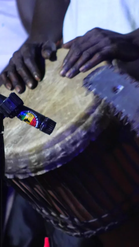 Black men standing playing djembe adorned with drum rings Stock Footage 230691136