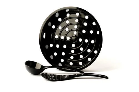 Black mesh multicooker steamer with plastic spoons for cooking isolated on wh Foto stock