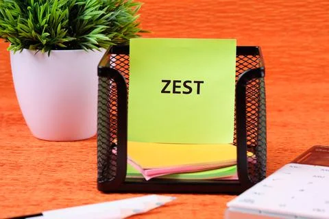 A black mesh notepad holder filled with colorful sticky notes sits on an or.. Stock Photos