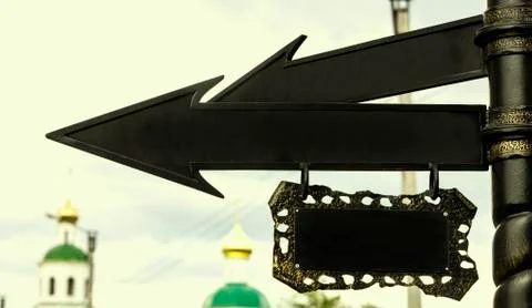 Black metal arrow pointer on the column on the background of the domes of the Stock Photos