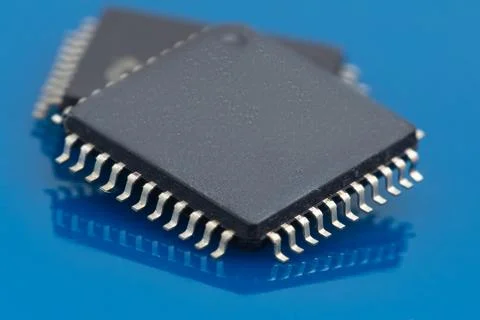 Black microchip rests on glossy blue surface Stock Photos