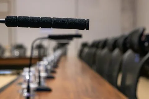 Black microphone in the foreground, in the blurred background are several oth Stock Photos