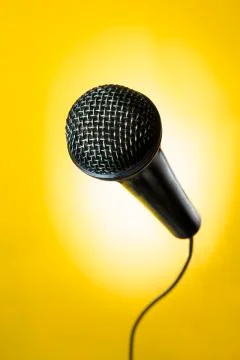 Black microphone in yellow background Stock Photos