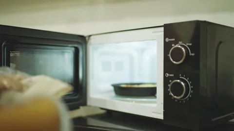 Black Microwave Oven with Open Door and Control Knobs in Kitchen Stock-Footage 336291124