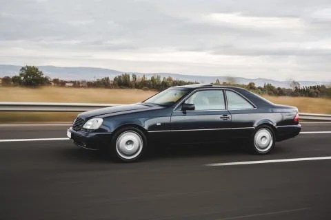 Black mid class sedan driving on the road Stock Photos