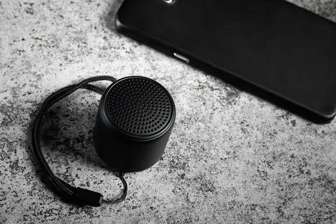 Black mini Bluetooth speaker and smartphone conected Stock Photos