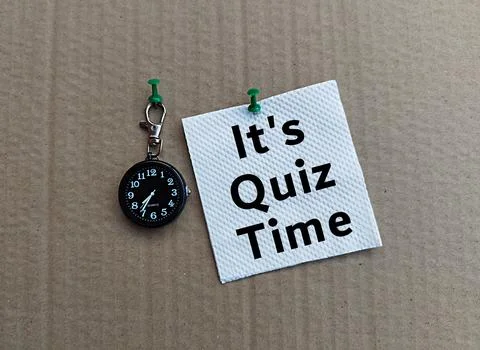 Black mini clock, white tissue, it's quiz time, gray background, box surface Stock Photos