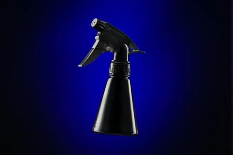 Black mini spray bottle over blue background Stock Photos