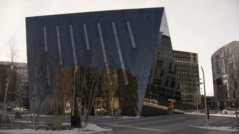 Black Mirrored building high tech pan to left with Woman Pedestrian waking in Stock Footage 89944856