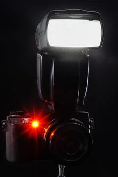 Black mirrorless camera with flash on black background Foto stock