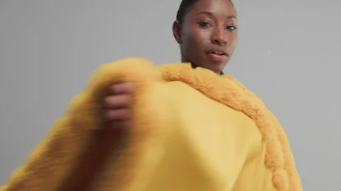 Black mixed race model in studio wear yellow outwear bright outumn look Stock Footage 101191753