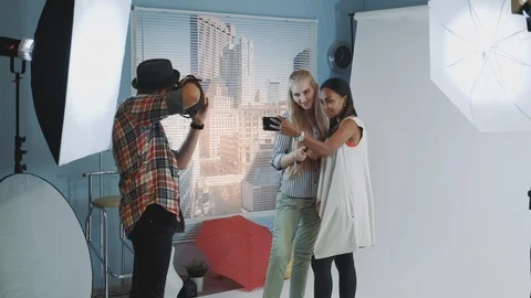 Black model with make-up artist making selfie while photographer together photos Видео 122584893
