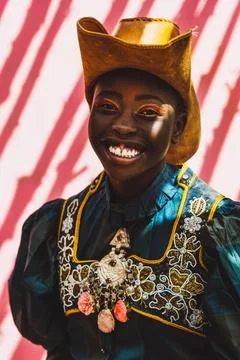 Black model with a pretty smile against a pink background. Stock Photos