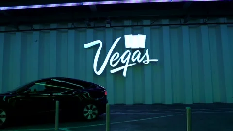 Black Model Y Tesla passes Neon Vegas Sign at LVCC Loop. Stock Footage 225537096