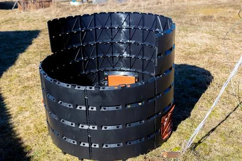 Black modular compost bin, segmented cylindrical design, interlocking panel.. Stock Photos