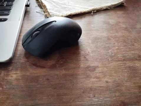 Black mouse on brown table background Stock Photos