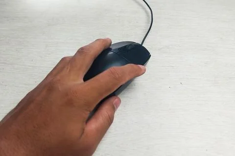 Black mouse with cable, held in hand Stock Photos