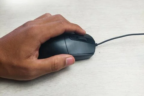 Black mouse with cable, held in hand Stock Photos