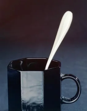 Black Mug With Spoon on Dark Background, Glossy Ceramic Cup Closeup for Cof.. Stock Photos