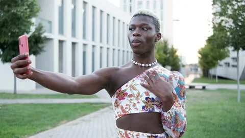 Black non binary person taking selfie in park Stock Footage 219653006