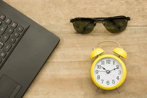 Black notebook  and yellow clock with eye glass on wooden Stock Photos