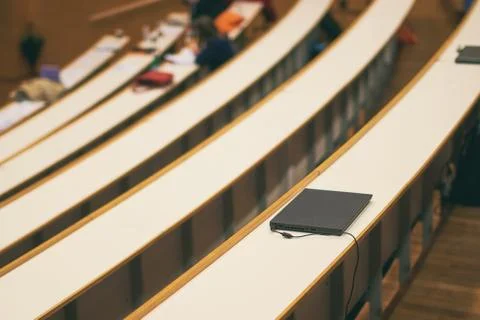 Black notebook computer on the desk in university auditorium Stock Photos