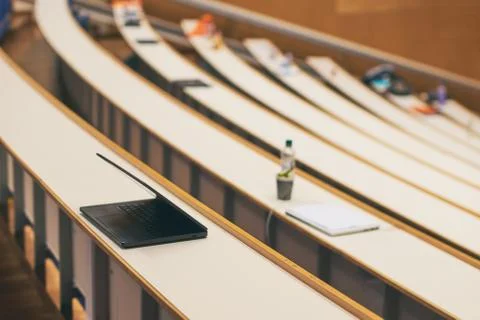 Black notebook computer on the desk in university auditorium Stock Photos