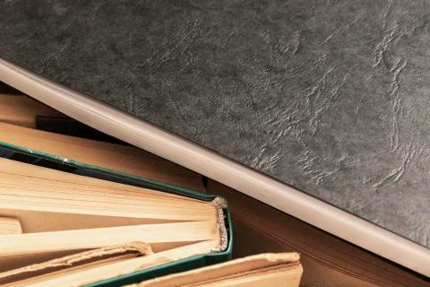 Black notebook lying on the side of books Stock Photos