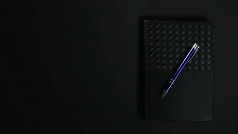 Black notebook with pen on dark background Stock Footage 327288580