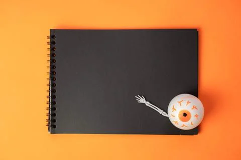 Black notebook on a spring with a toy eye , a creative Halloween concept Stock Photos