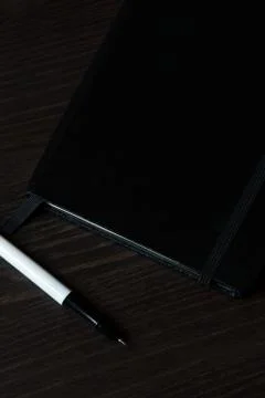 Black Notebook on the table with black pen Stock Photos