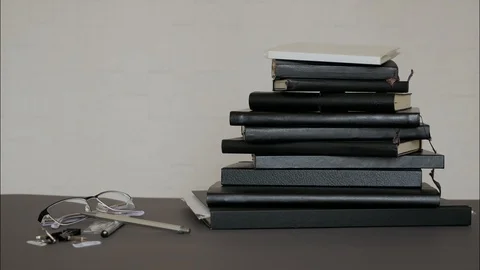 Black notepads stacking up on office table - Stop motion. Stock Footage 129813057