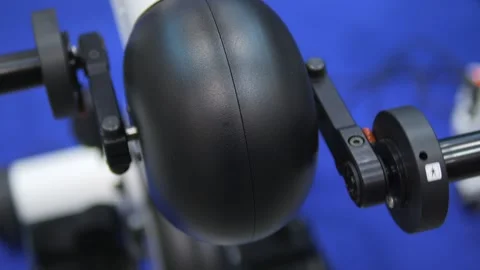A black object with a white handle is on a blue surface Stock Footage 297733287