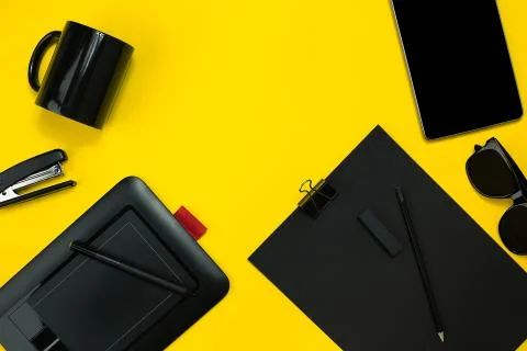 Black objects from the office on a yellow background. Work and creativity. Top Stock Photos