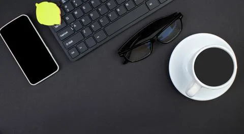 Black office table with computer, pen and a cup of coffee, lot of things. T.. Stock Photos