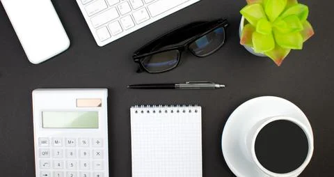 Black office table with computer, pen and a cup of coffee, lot of things. T.. Stock Photos