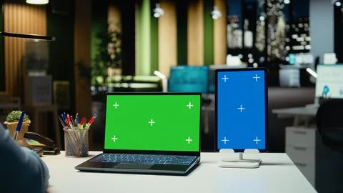 Black office worker using green screen on laptop and blue screen on tablet Stock Photos