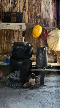 Black old kettle sitting on small old firewood stove with charcoal. Stock Photos